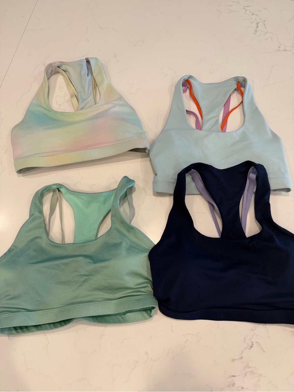 Fabletics Assorted Racerback Sports Bras in Mint, Pastel, Light Blue, and Navy